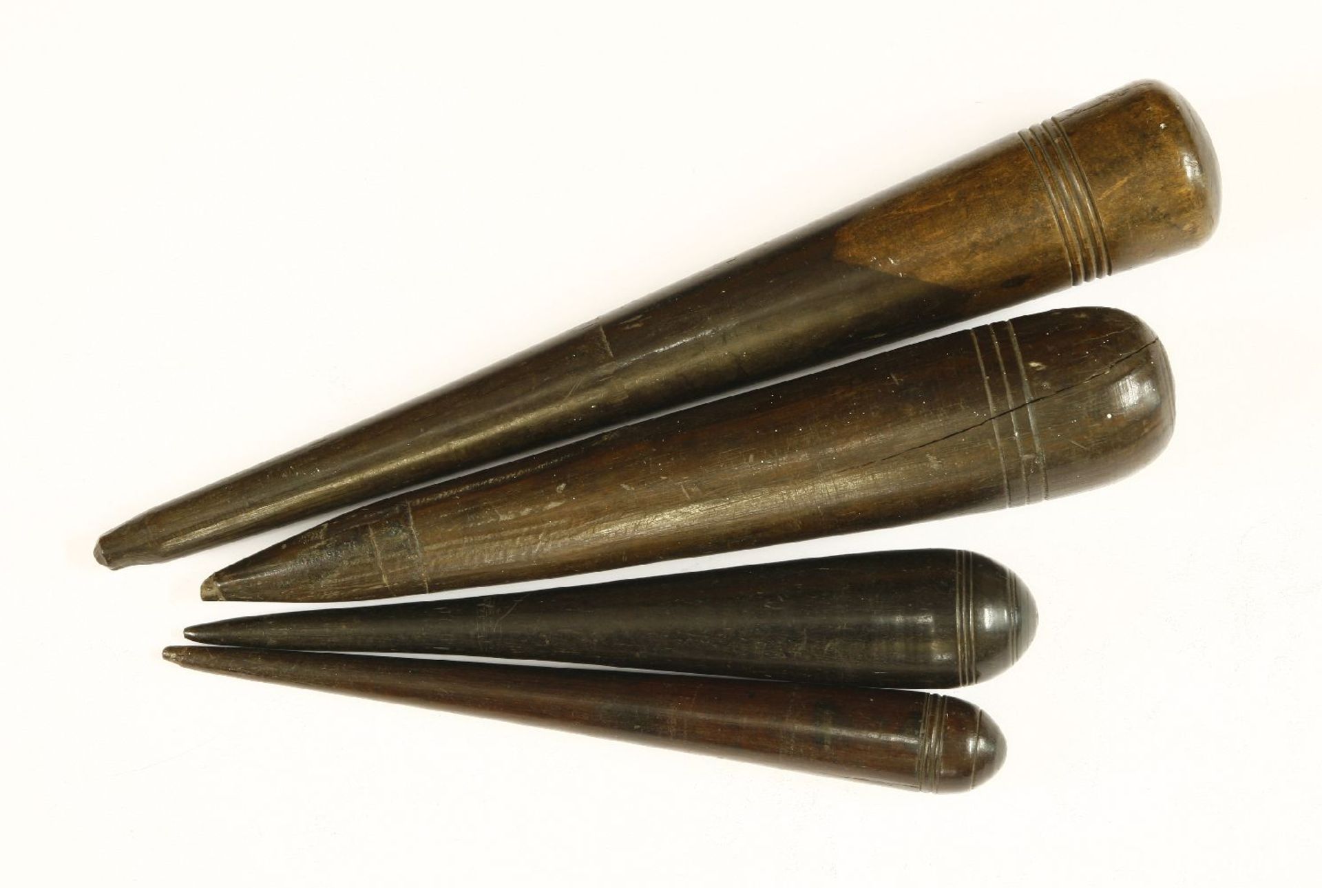 Four turned fids,19th century, each with routed rings, the terminals 23 to 26.5cm long (4)