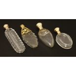 Four clear glass scent bottles,19th century, two of teardrop shape with rolled gold and silver