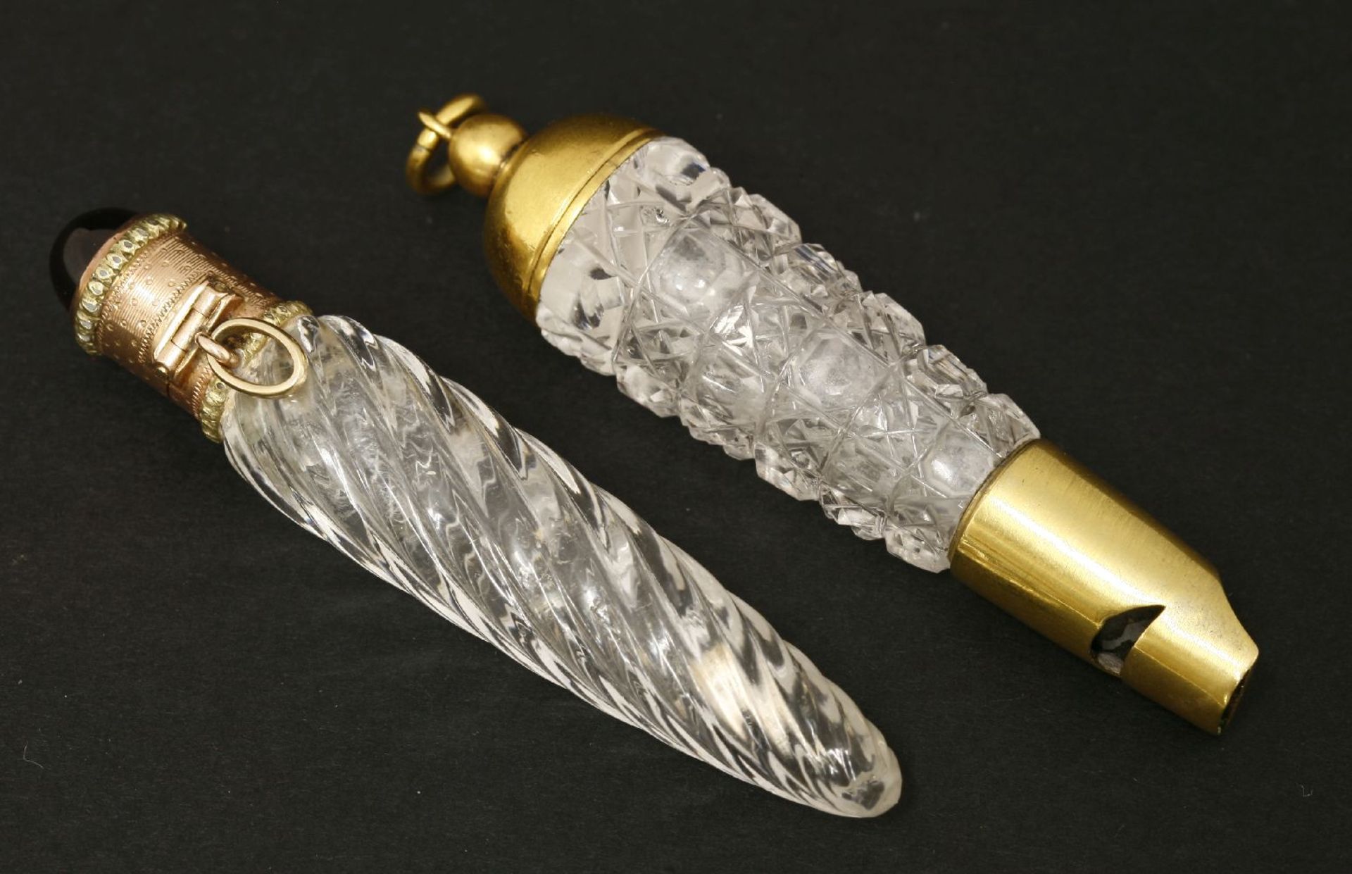 Two clear glass scent bottles,mid-19th century,one with a wrythen moulded body, below an engine