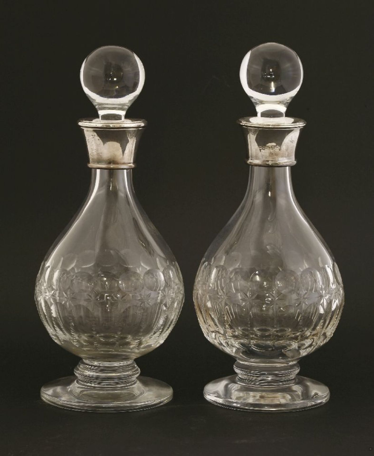 Two modern silver-mounted decanters,both with cut glass bodies, each on a circular foot,28cm high (