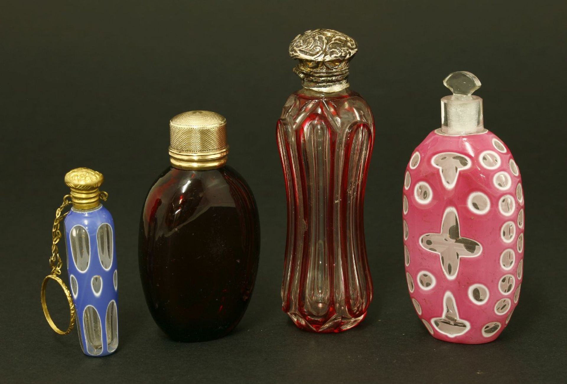 Four Victorian scent bottles,hallmarks indistinct,a faceted and flash-dipped waisted body below a