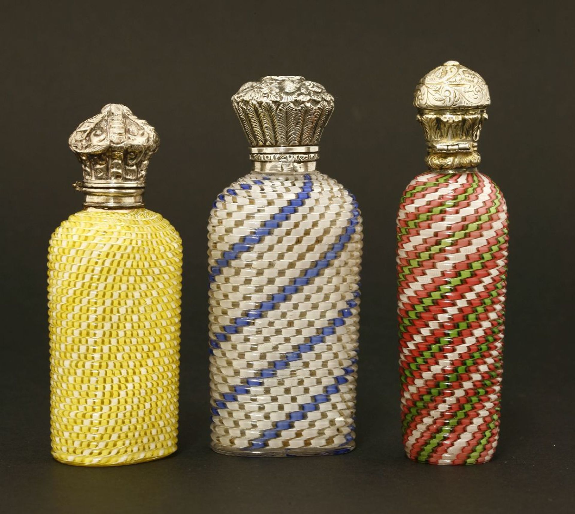 Three scent bottles,19th century, each clear glass cased in colours cut into close geometric