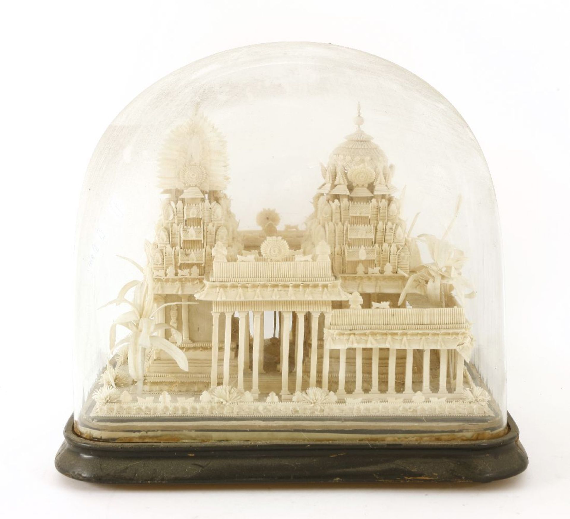 A carved wooden model of a Thai temple ruin, 19th century, raised under a glass dome,50cm wide30cm