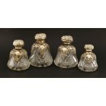 A set of four cut and moulded glass cologne bottles,in three sizes, each with ornately cast and