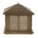 A folk art walnut and oak cheese cupboard,19th century, the simulated shingle roof over glazed doors