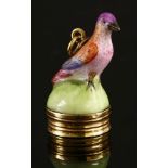 A hand-painted porcelain bird seal,with a polychrome bird to a green base, with a gold banded seal