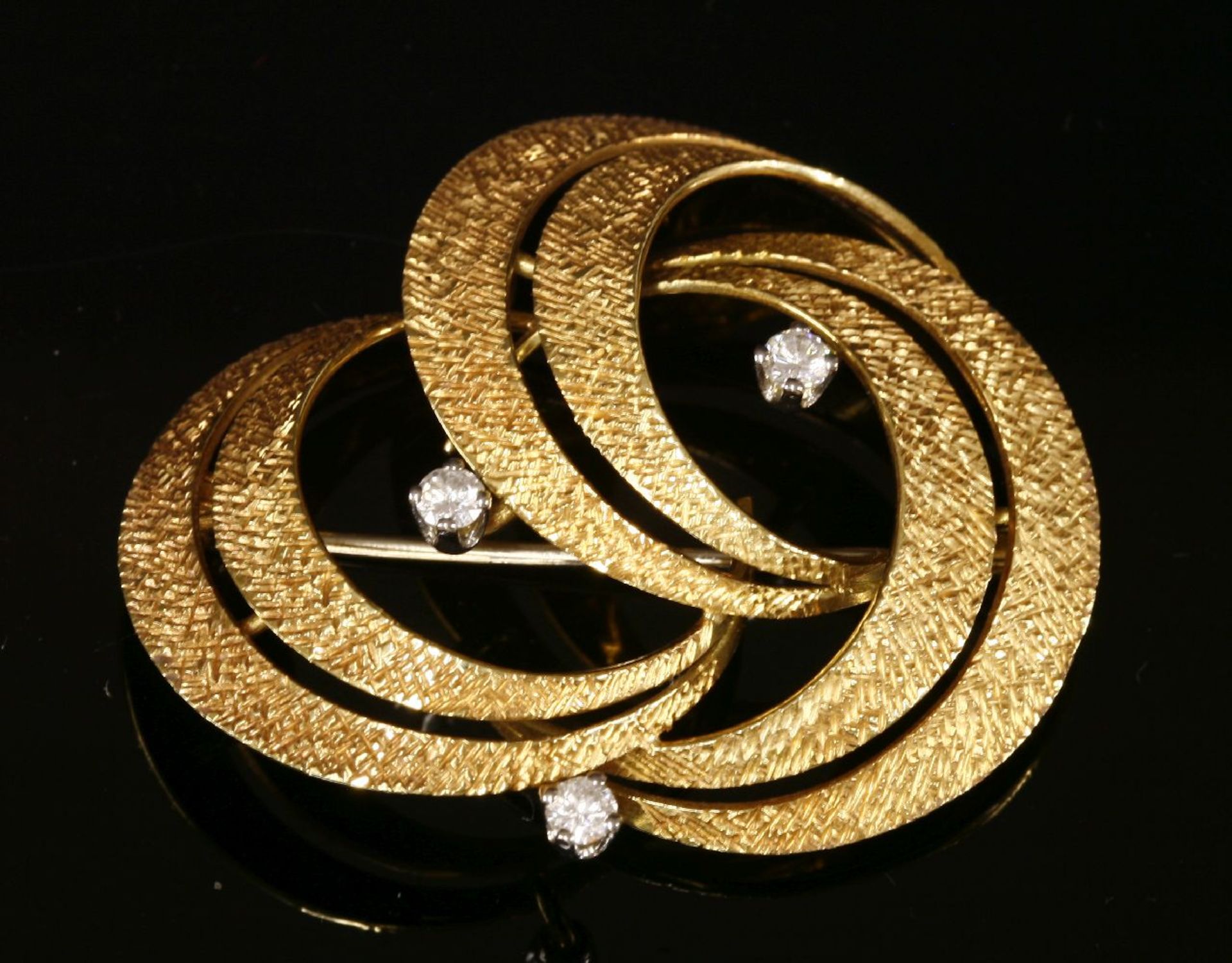 A Swiss, diamond set, gold knot brooch, c.1950, by Gübelin. With three pairs of arched crescents,
