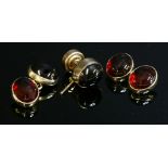 A pair of 9ct gold garnet cufflinks,composed of pairs of oval cabochon garnets, rub set to plain