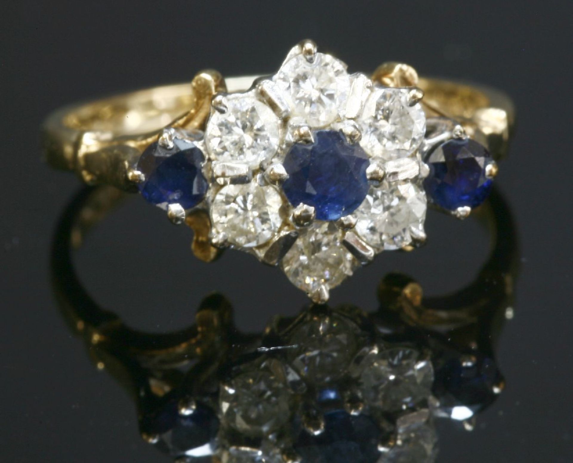 A 9ct gold sapphire and diamond cluster ring,with sapphire set shoulders, London 1981. 2.45g. - Image 2 of 2