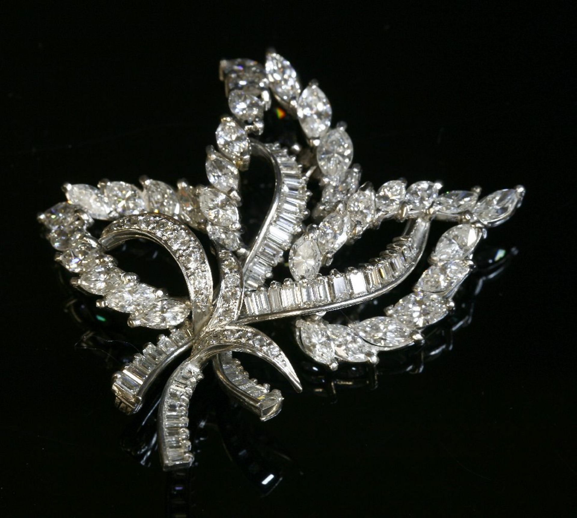 A platinum and diamond set leaf spray brooch, c.1950, with a series of open leaf shapes composed