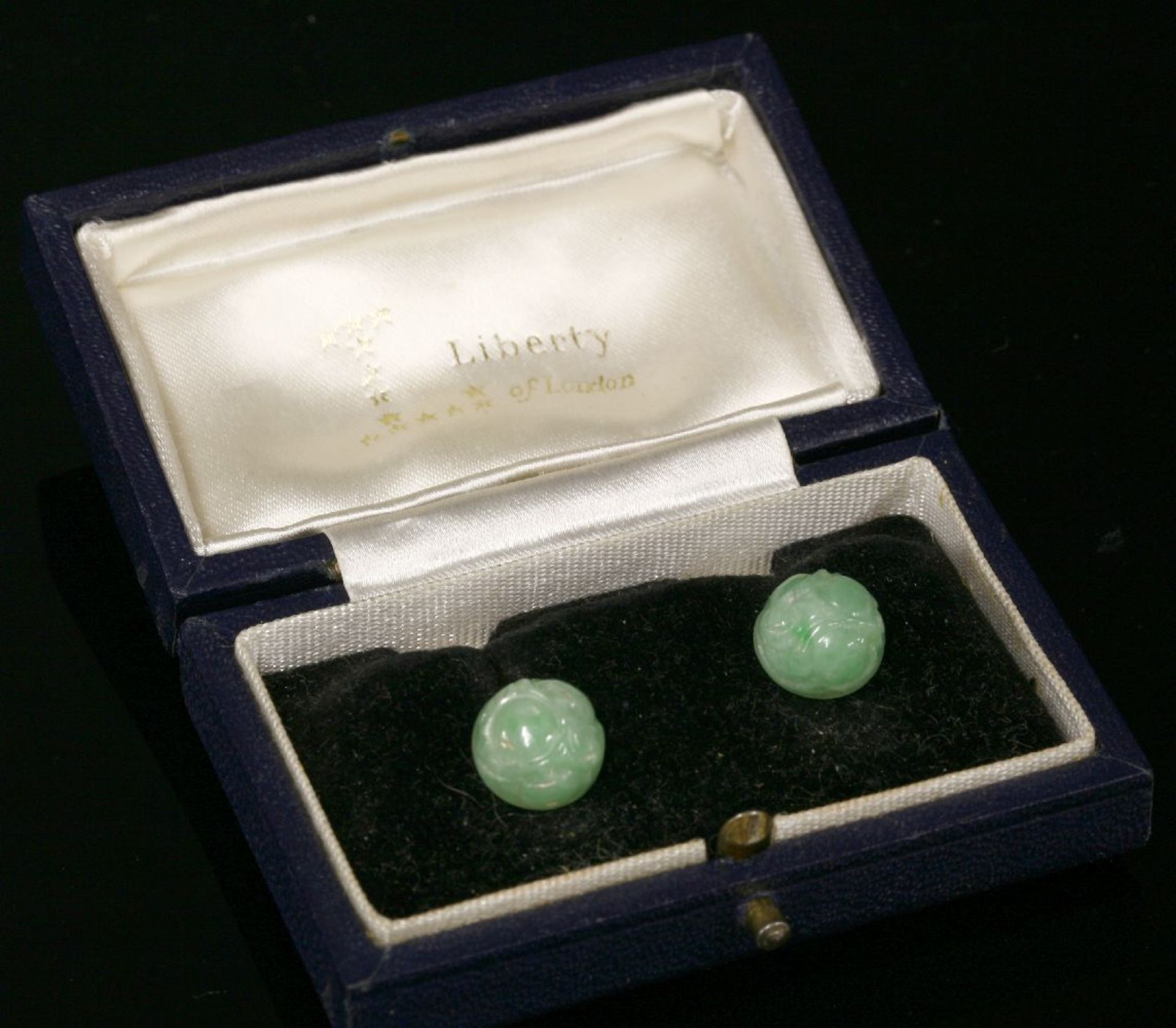 A pair of 9ct white gold jade stud earrings by Cropp & Farr, c.1960,each carved jade half bead,