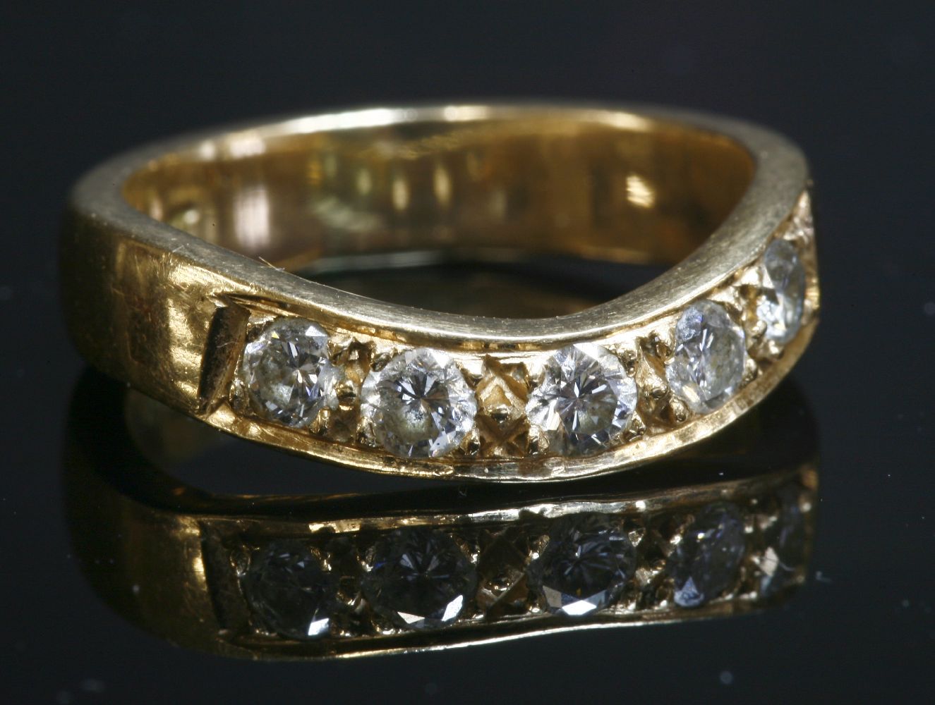 A gold diamond set wave half eternity ring,with five brilliant cut diamonds, grain set to a flat