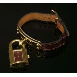 A ladies' gold plated Hermès quartz Kelly strap watch, with a padlock form watch head with