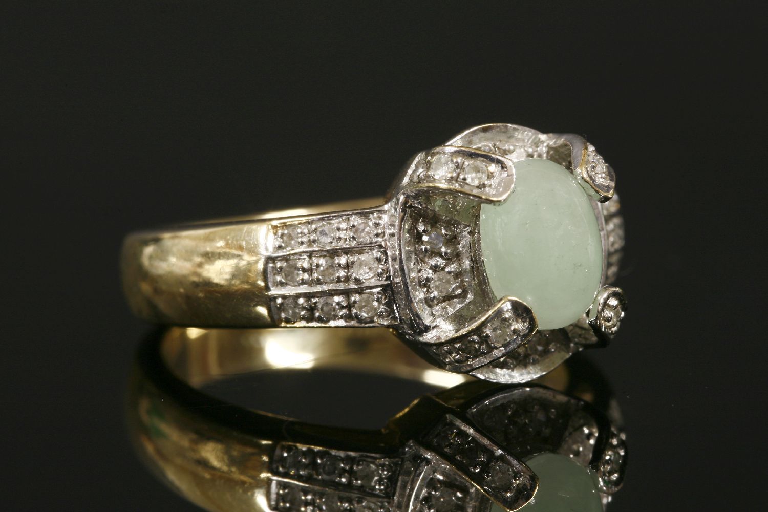 A 9ct gold jade cabochon and diamond cluster ring,with three-row diamond set shoulders. 4.75g.Finger