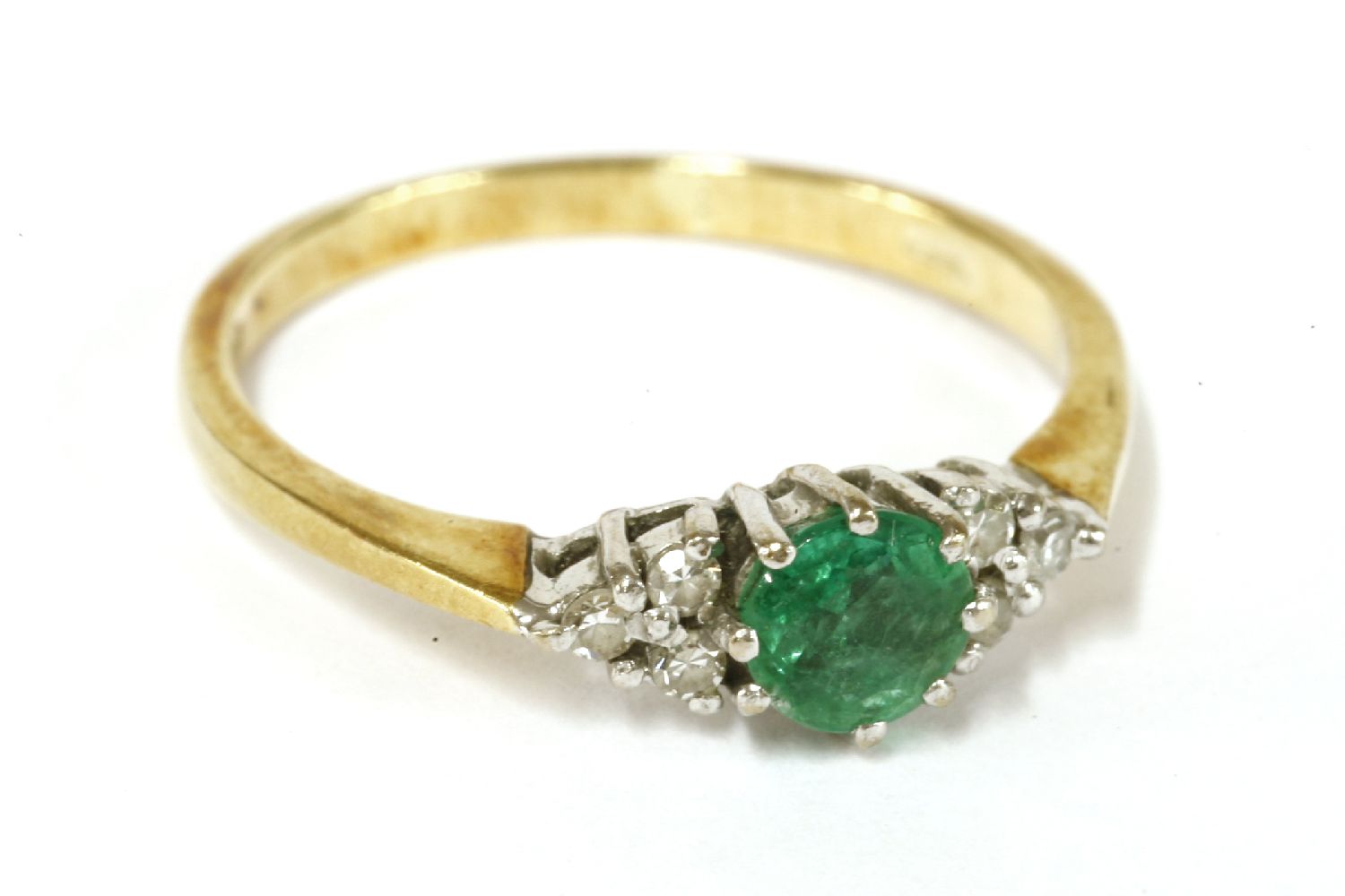 An 18ct gold circular cut emerald ring, flanked with trefoil clusters of diamonds, size N2.27g