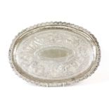 A Burmese silver tray, of oval form with an arcaded border, with a central embossed scene of figures