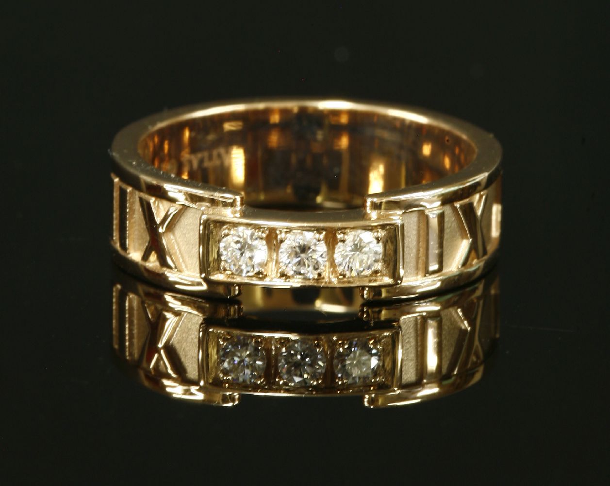 A ladies' 18ct rose gold diamond set Tiffany 'Atlas' band ring, with three brilliant cut diamonds,