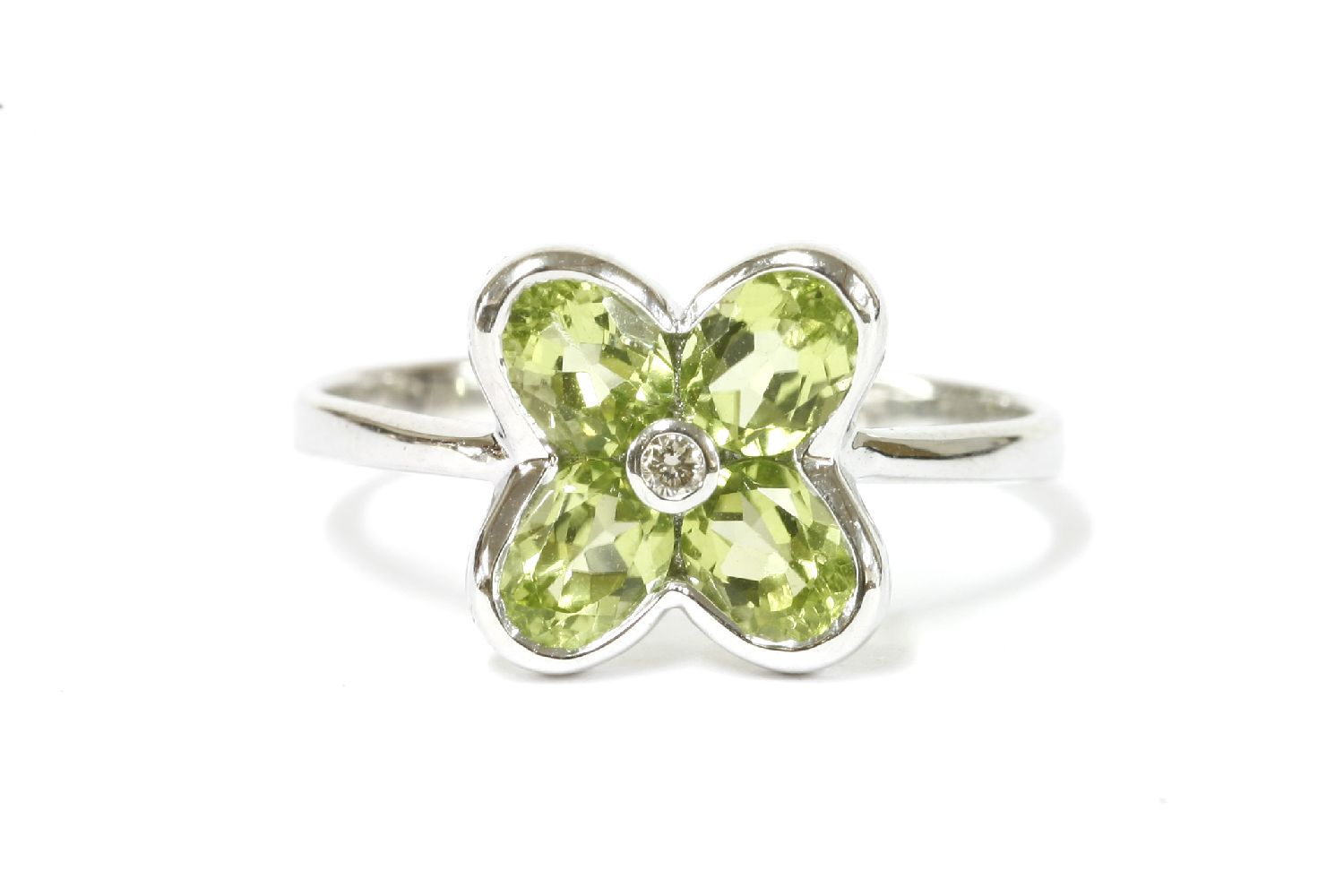 A white gold peridot and diamond daisy ring, rub set to a plain polished shank, marked 375