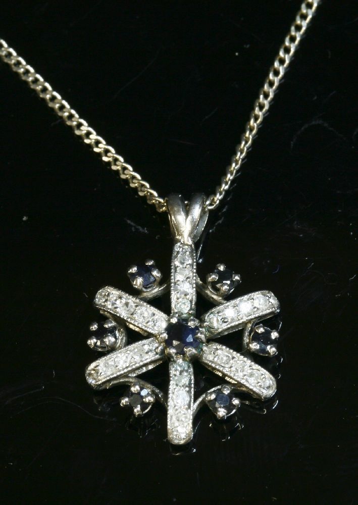 A sapphire and diamond cluster pendant,with a central circular mixed cut sapphire, with radiating