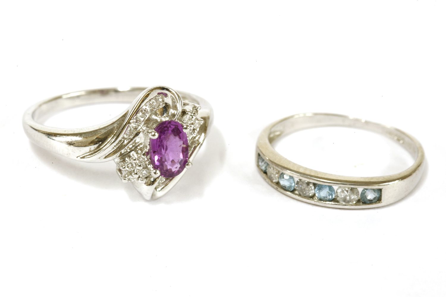 A white gold purplish/pink sapphire and diamond crossover cluster ring, marked 14k, size O½, a 9ct