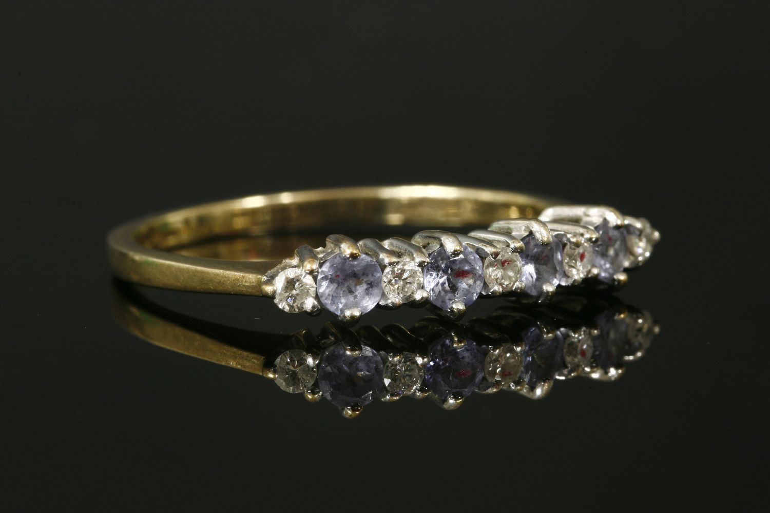 A 9ct gold tanzanite and diamond nine stone ring,with a white claw setting and yellow shank. 2.01g.