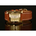 A ladies' gold plated Hermès Heure H quartz strap watch. Model no. HH1.201. Square engine turned