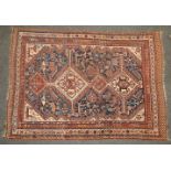 A hand knotted Persian Qashqai rug, the blue and biscuit fields with quadruple pendant centre,
