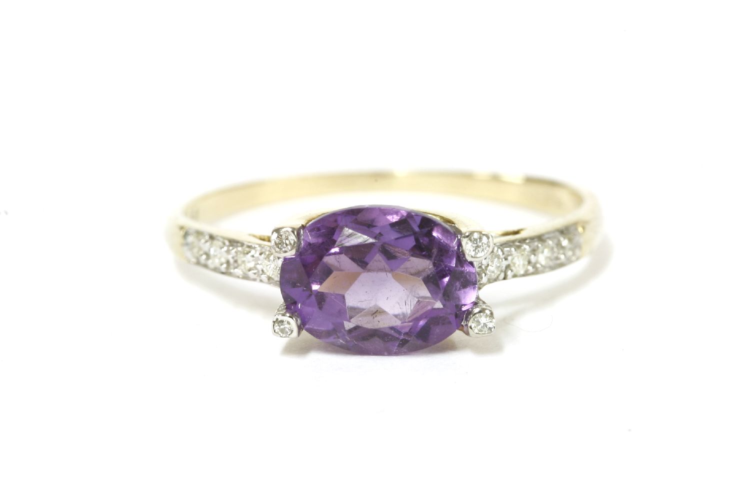 A 9ct gold single stone oval cut amethyst and diamond ring, with diamond set claws and shoulders