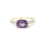 A 9ct gold single stone oval cut amethyst and diamond ring, with diamond set claws and shoulders