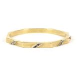 A hollow gold octagonal hinge bangle, with three diagonal bars set with synthetic spinels and