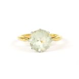 A gold single stone round cut aquamarine ring, claw set with tapering shoulders to a plain