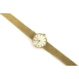 A ladies 9ct gold Omega mechanical bracelet watch, silvered dial, baton markers, with tapering