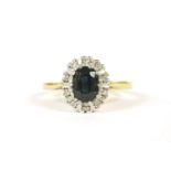 An 18ct gold oval cut sapphire and diamond cluster ring, 4.19g