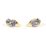 A pair of 9ct gold three stone tanzanite and diamond crossover stud earrings, 2.71g