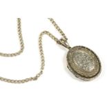 A large Victorian silver locket, raised central boss with engraved decoration, with scalloped border