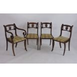 Four Regency mahogany dining chairs, with carved rails over drop in seats and sabre legs,