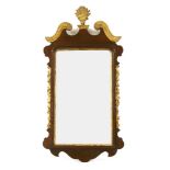 A George III style mahogany and gilt highlighted wall mirror, the scrolling break arch pediment over