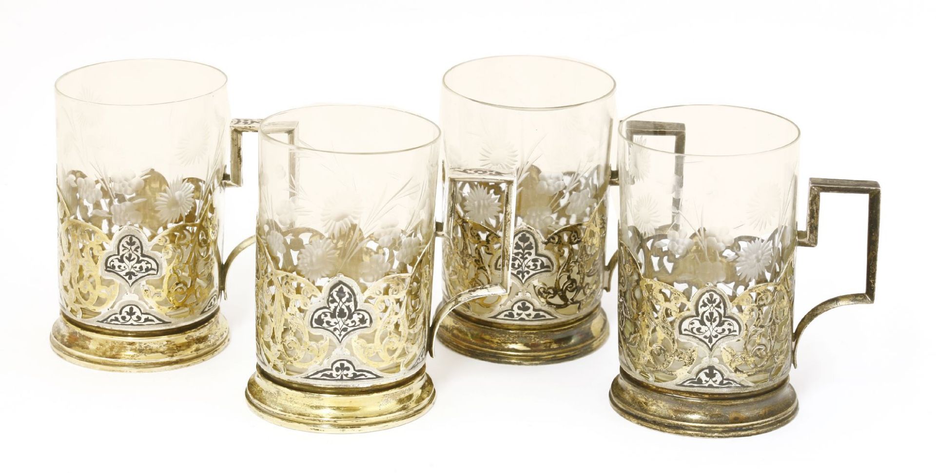 Four gilt white metal cup holders,with niello and engraved decoration, possibly Russian,11cm high