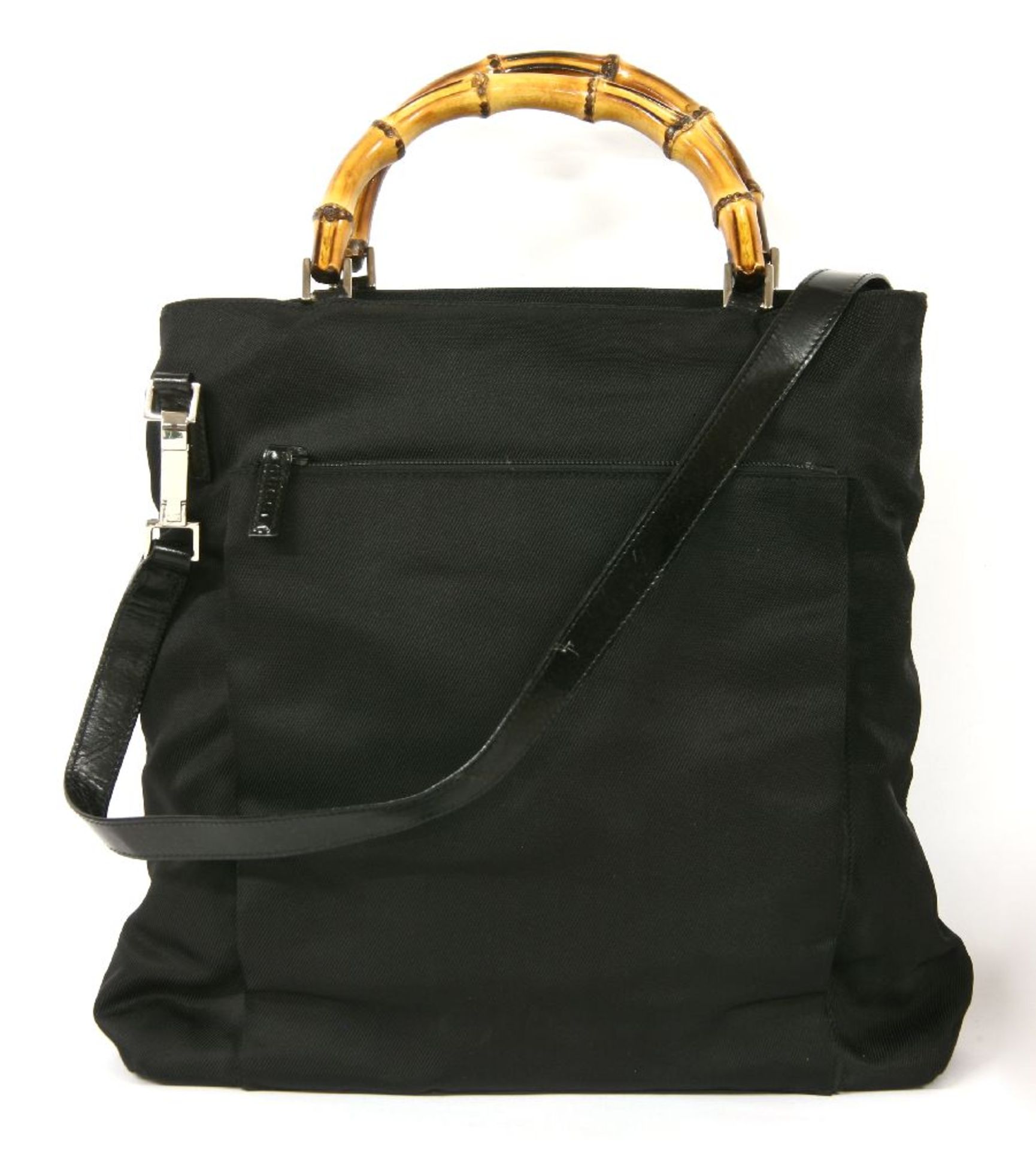 A Gucci black canvas cross-body handbag, featuring the maker's curved rigid bamboo handle,