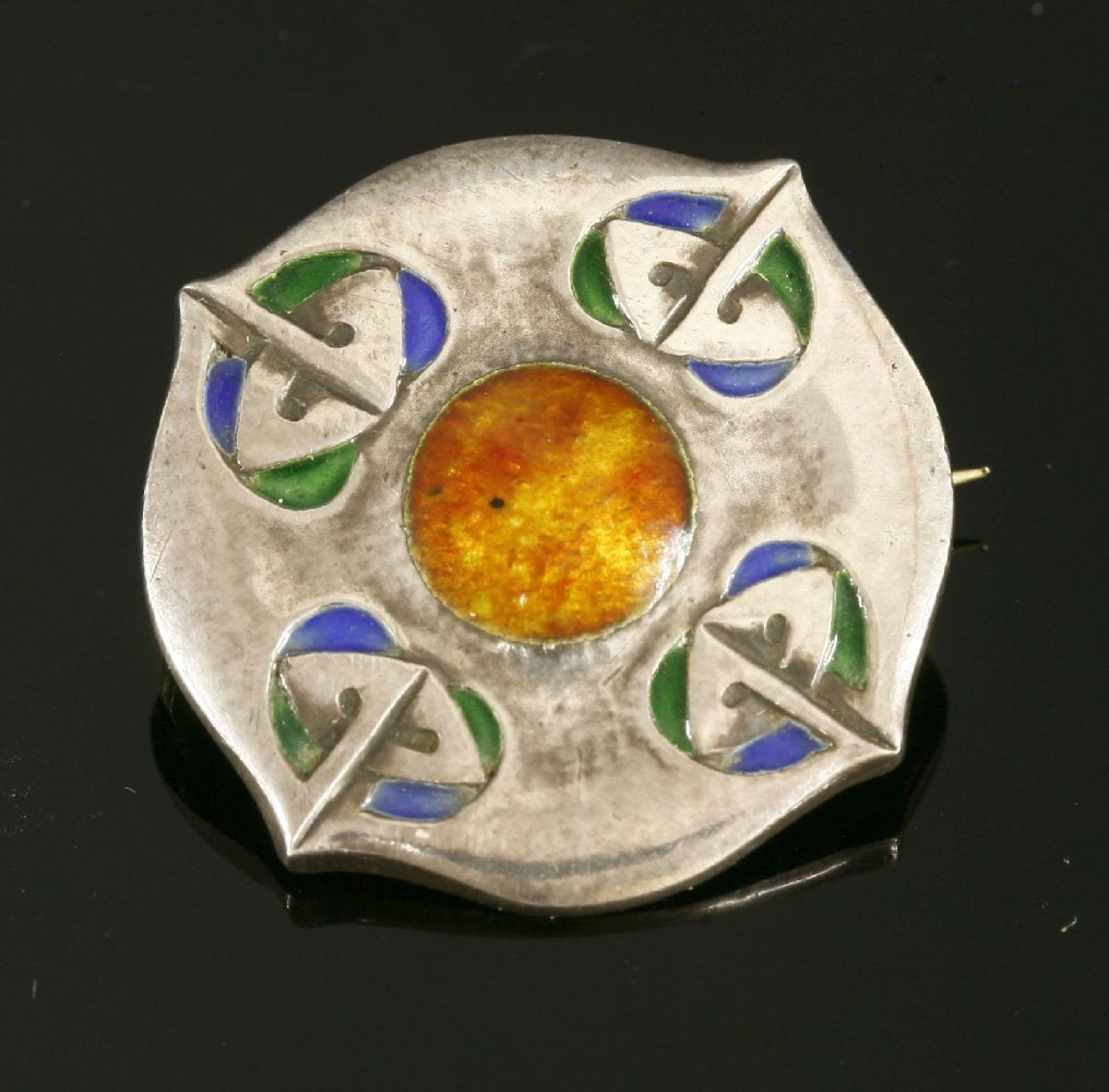 A Liberty & Co. silver and enamelled brooch, of circular shield form with a yellow and orange