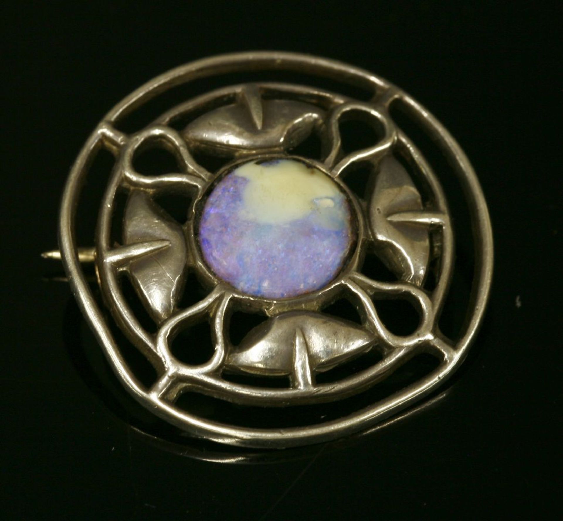 A Liberty and Co. silver and opal brooch,of pierced circular form, rub set to the centre with a