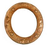 An Arts and Crafts oval copper mirror,with a bevelled plate with stylised designs and screw studs,