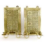 A pair of brass wall sconces,c.1890, in the manner of Thomas Jekyll, each rectangular backplate cast