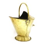 An Arts and Crafts brass coal scuttle, with stylised flower designs, a swing handle, indistinct