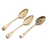 A pair of Georgian silver berry spoons, together with an 18th century silver berry spoon