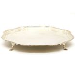 A silver salver with pie crust rim, raised on out swept feet, by Stevenson & Law, Sheffield, 1924,