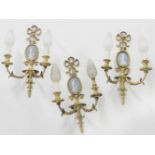 A set of three gilt metal twin branch wall light, inset with jasperware plaque, 46cm high