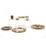 Silver items, comprising: three ashtrays and four silver topped glass scent bottles, tallest 10.5cm