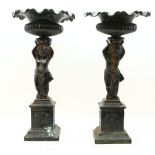 A pair of cast iron cherub ornaments/urns, raised on square bases, 63cm high