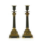 A pair of French Empire style bronze and ormolu candlesticks, the tapering fluted columns